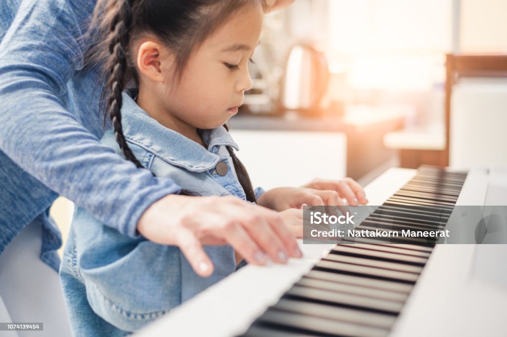 Enfant au piano avec sa professeure
